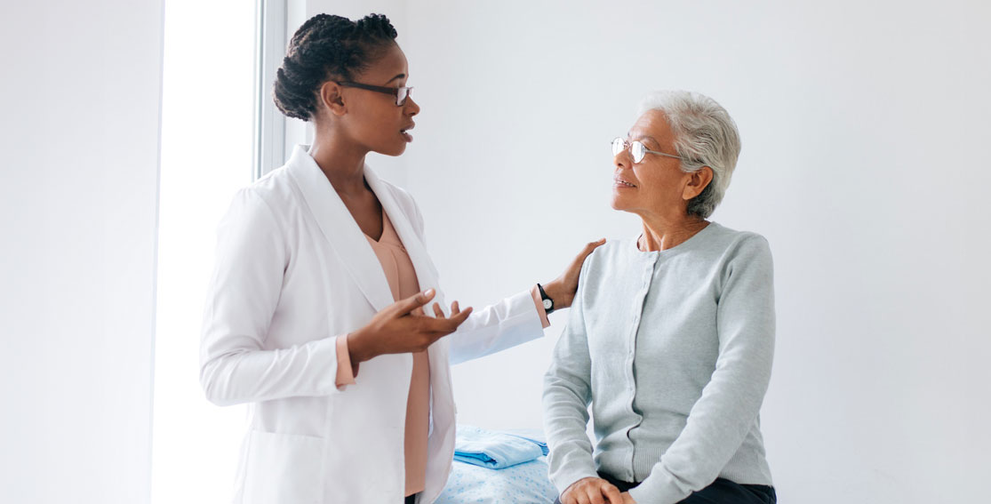 Woman doctor talking to an elderly woman patient.
