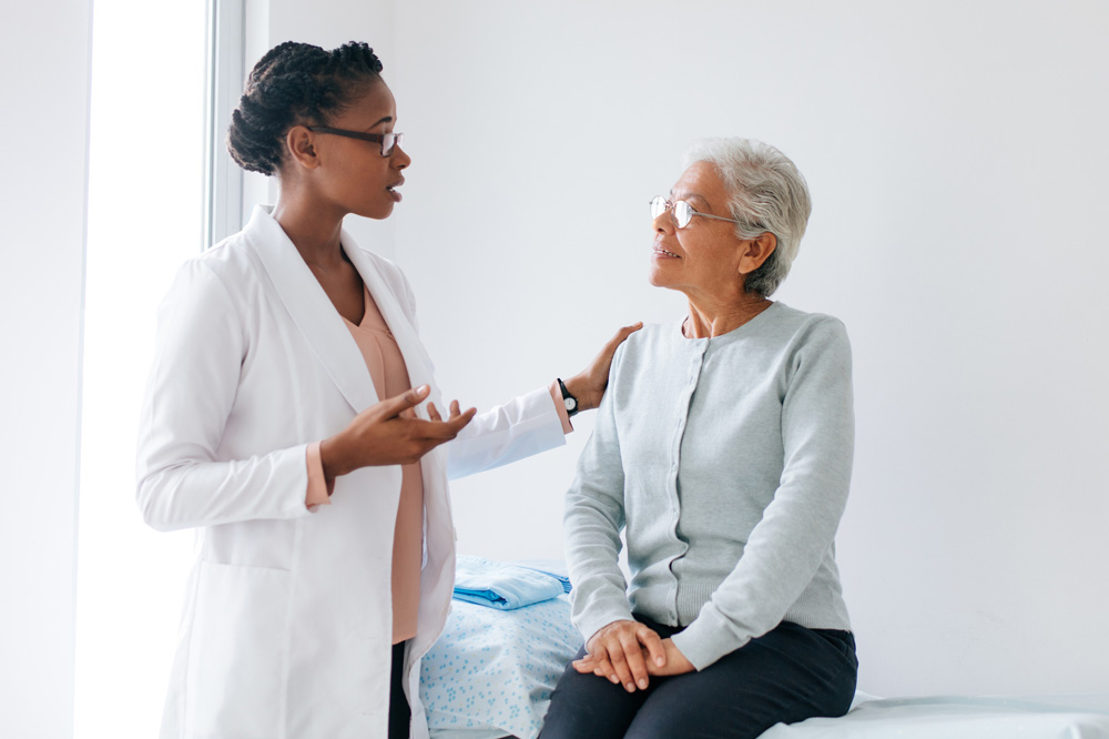 Woman doctor talking to an elderly woman patient.