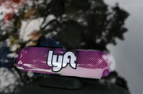 the lyft ride-sharing company's in-car signage and a view of trees in the background