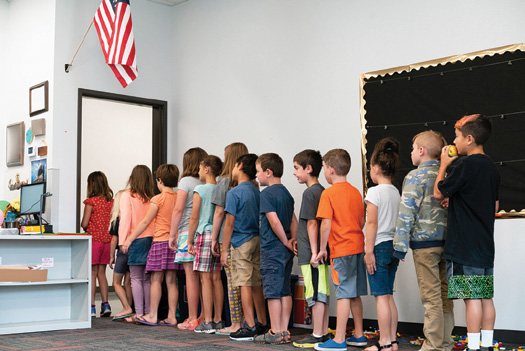 elementary students line up to exit their small classroom