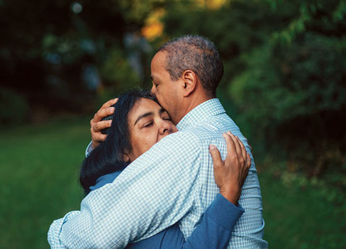 A man and a woman embrace in a hug.